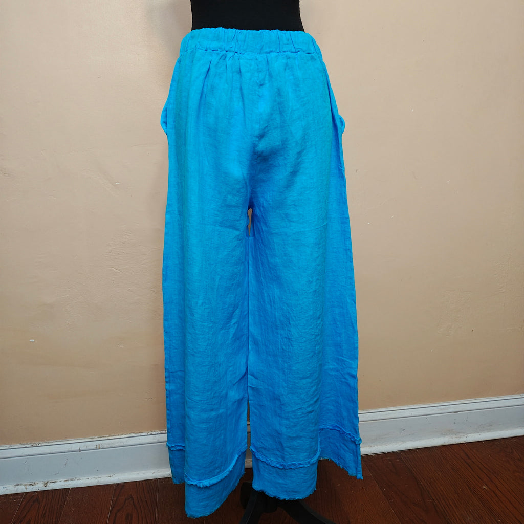 Blue pants on a mannequin against a beige wall.